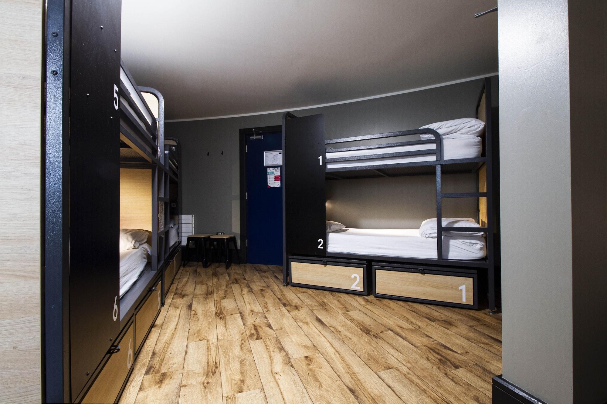 Cama en habitación compartida mixta con baño compartido
