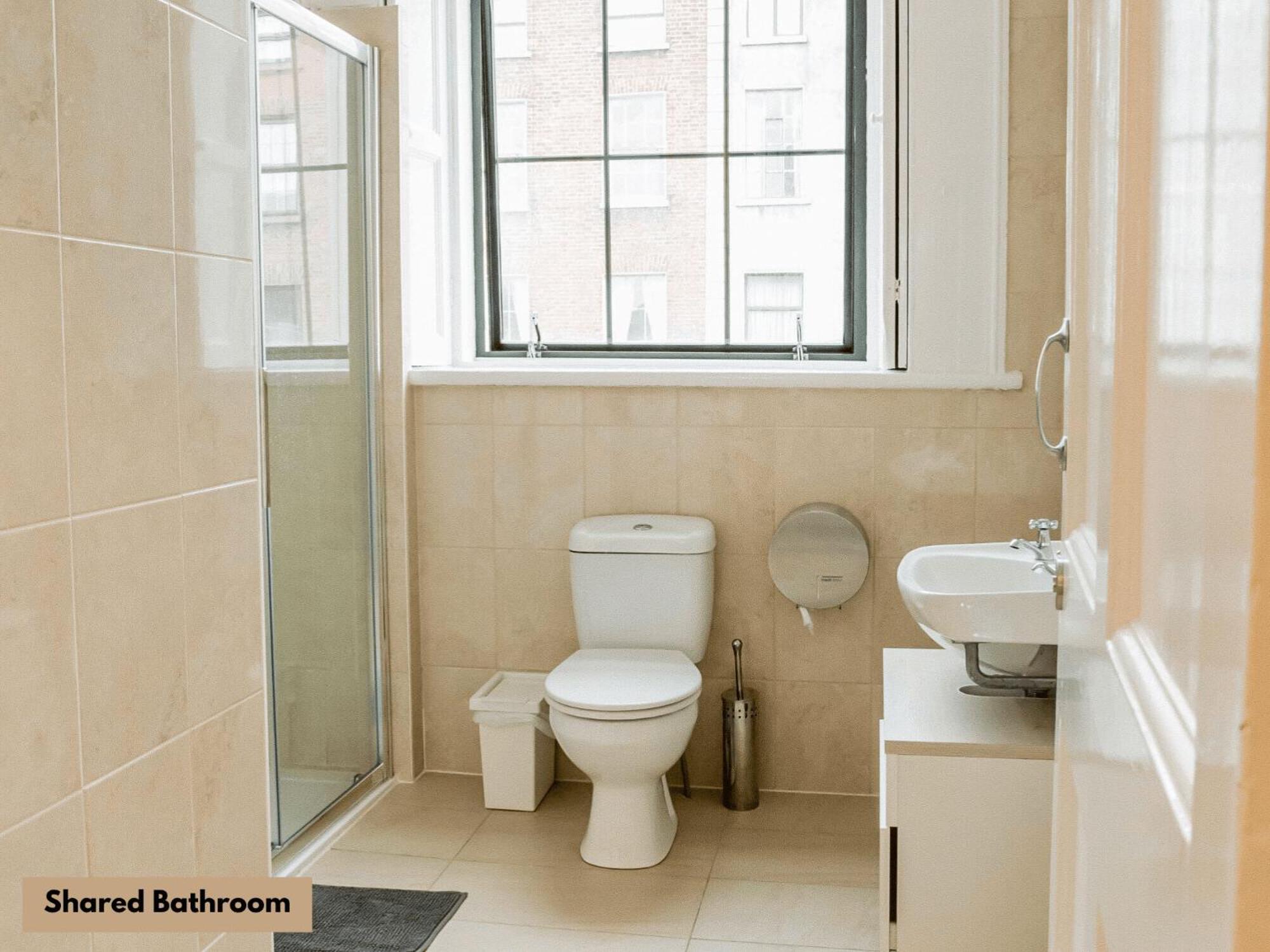 Cama en habitación compartida mixta con 3 camas y baño compartido